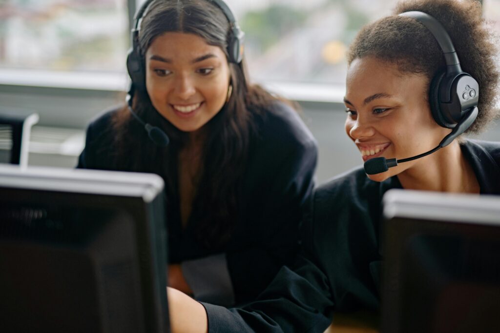 Two cheerful call center agents at work, engaging with customers and providing support.